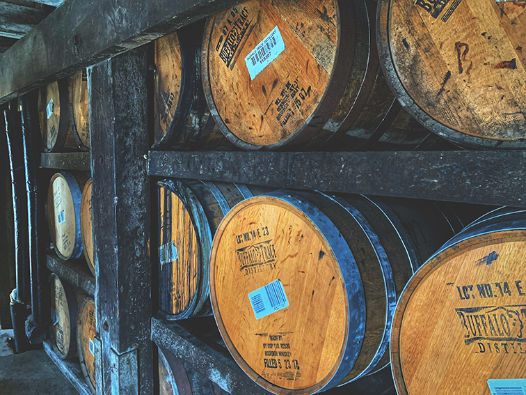 photo of whiskey barrels aging in a warehouse